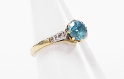 An aquamarine dress ring, the central aquamarine in claw setting, with white metal shoulders on a yellow metal band marked 9ct, ring size M, 2.5g all in.