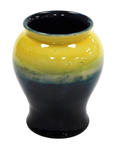 A Moorcroft pottery vase, of baluster form, in graduated yellow and blue glaze, impressed marks and facsimile signature, 15cm high/