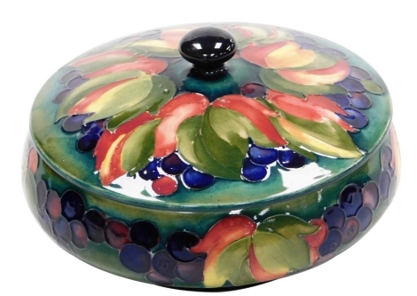 A Moorcroft pottery Leaf and Berry pattern powder bowl and cover, of circular form, impressed marks, 20cm diameter, (AF).