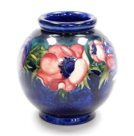 A Moorcroft pottery vase decorated in the Anemone pattern, against a cobalt blue ground of globular form, impressed and painted marks, 15.5cm high.