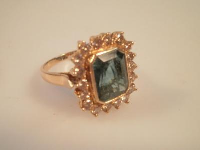 A dress ring set with an emerald cut green stone (possibly touramaline)