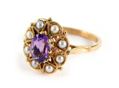 An early 20thC 9ct gold ladies amethyst and pearl ring, the oval claw set purple stone, surrounded by small pearls, on a part pierced shank, size P, marked 9ct, 4g all in.