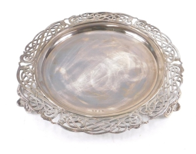 A 20thC Irish silver salver, possibly Larry Gunning, the inner plain circular section with a pierced scroll and serpent border, on pierced clover leaf feet, Dublin 1964, 58oz.