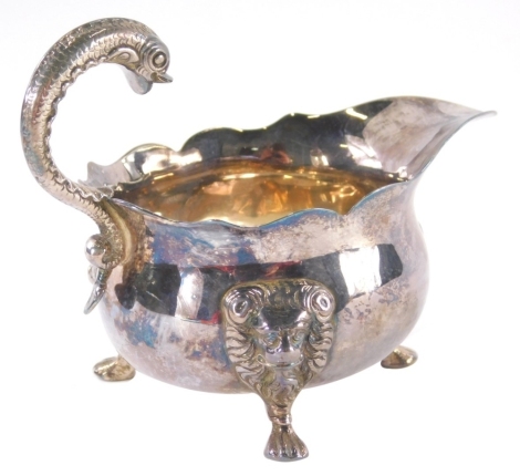 A George II silver sauce boat, with S-scroll dolphin handle, ram's capped triple hoof supports and flared rim, Newcastle 1753, 10cm high, 4oz.