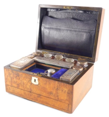 A late 19thC walnut travelling box, of rectangular form, the hinged lid revealing a fitted interior containing various boxes, bottles, etc., with cut glass and silver plated tops, various costume jewellery, silver and other items, buckles, etc., with a fr