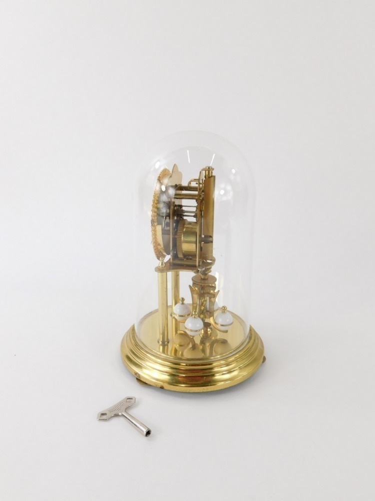 A Kundo anniversary clock in Perspex case, with visible movement, 8cm