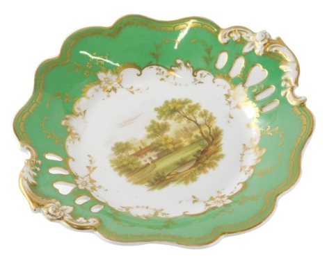 A 19thC porcelain dish, of shaped circular form, hand painted with a scene of trees before house and a shaped part pierced border in green with gilt highlights, printed marks beneath, 23cm wide.