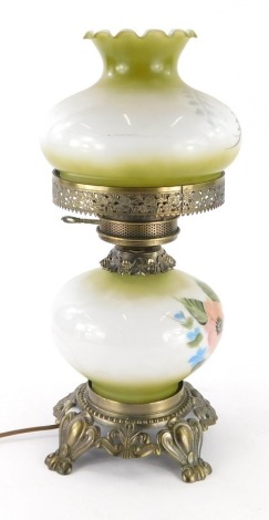 A 20thC Edwardian style milk glass table lamp, with removable shade, decorated with flowers, on a shaped metal base with modern electrical fitting, 44cm high.