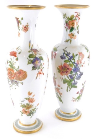 A pair of 19thC continental glass vases, of large proportion, each with trumpet necks and form, hand painted with flowers on a milk glass ground, with gilt highlights, unmarked, 56cm high. (2)