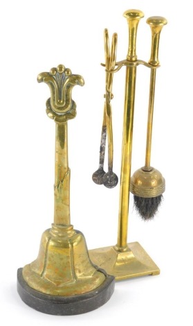 A 19thC brass bell shaped door stop, the handle with a fleur de lis finial, 36cm high, and a brass fire side companion set, with coal nips, and brush. (2)