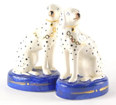 A pair of Staffordshire style Dalmation figures, predominately in black, white and blue with gilt highlights, 15cm high.