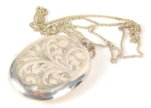 An Elizabeth II silver locket of oval form partially chased on slender link necklace, Birmingham 1972, 5cm high.