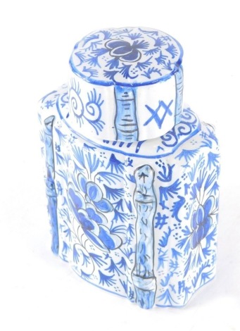 A 19thC Dutch Delft pottery tea caddy, of shouldered form with removable lid, profusely decorated with flowers on a shaped base, marked R beneath, 15cm high.