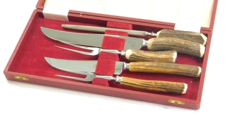 A horn handled carving set, with chrome blades in fitted case, 39cm wide.