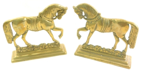 A pair of brass horse doorstops, each with front leg raised, 21cm high. (2)