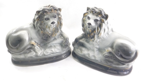 A pair of mid Victorian Staffordshire pottery lion figures, in grey colourway with gilt highlights, unmarked, 25cm high. (2)