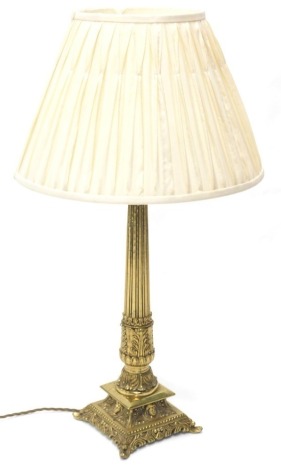 A gilt brass table lamp, with pleated shade, reeded column and square tapering base, 75cm high overall.