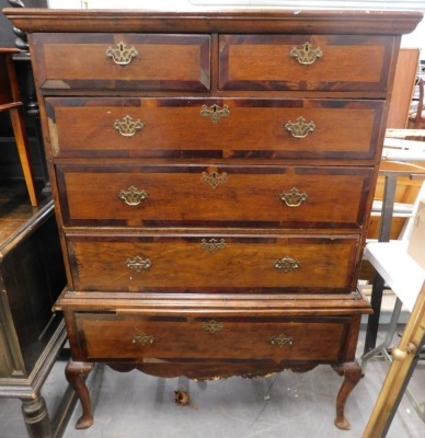 A 19thC oak and mahogany cross banded secretaire chest on stand, the top with a moulded cornice above two short drawers, a fitted drawer and two further drawers, the base with long drawer above a shaped apron on cabriole legs with pointed pad feet, 162cm