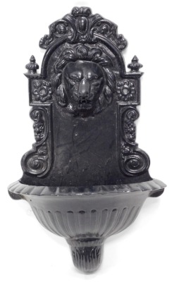 A cast resin wall mounted fountain, decorated with a lion mask, 63cm high.