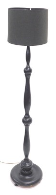 A black painted turned wooden standard lamp and shade, 159cm high. WARNING! This lot contains untested or unsafe electrical items. It is supplied for scrap or re-conditioning only. TRADE ONLY