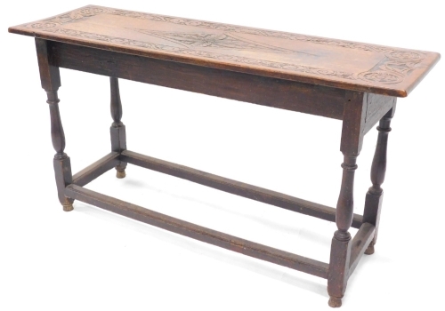 An oak low table, the rectangular top with a carved border on turned supports and plain stretchers, constructed from old timber, 66cm high, 124cm wide, 39cm deep.