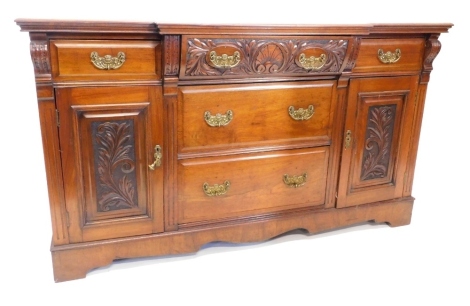 A late Victorian breakfront sideboard, the top with a moulded edge above an arrangement of five drawers and two carved panelled doors, on bracket feet, 89cm high, 153cm wide, 51cm deep.