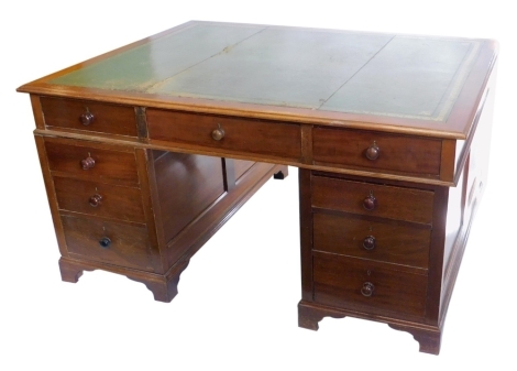 A mahogany pedestal partner's desk, the rectangular top with a green leather inset and a moulded edge, above an arrangement of nine drawers to each side, flanked by panelled sides, on bracket feet, the top 122cm x 152cm.