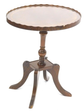 A mahogany occasional table, the oval top with a raised gallery and a boxwood and cross banded border, on a turned column and splayed reeded legs, 48cm wide.