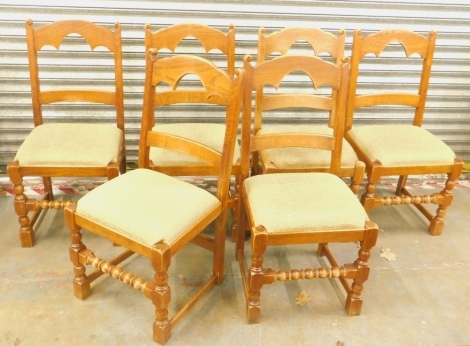 A set of six oak dining chairs, each with a shaped back and a drop in seat, on turned legs. The upholstery in this lot does not comply with the 1988 (Fire & Fire Furnishing) Regulations, unless sold to a known exporter or upholsterer it will be cut from t