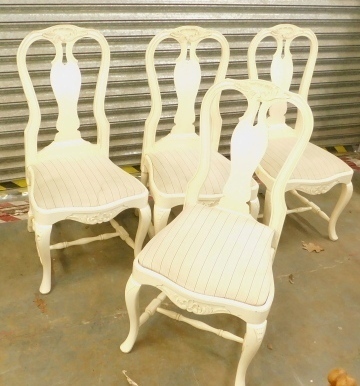 A set of four cream painted dining chairs, in the Queen Anne style, each with a part pierced and solid splat, shaped back, a drop in seat with striped fabric, on cabriole legs with H-stretcher.