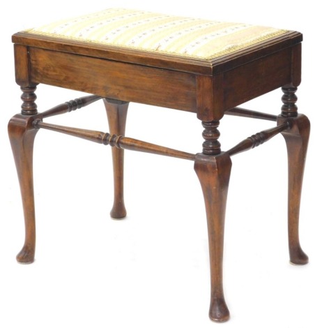 An Edwardian stained beech piano stool, the hinged lid with a padded seat, on cabriole legs and pad feet, 58cm diameter. (AF)