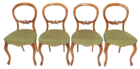 A set of four Victorian walnut balloon back chairs, each with a carved crest, a green upholstered padded seat, on cabriole legs, 123cm x 183cm.