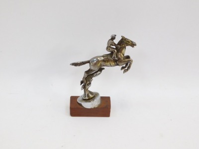 A Desmo brass and chrome finish car mascot, of a horse jumping the fence with jockey, on later applied wooden base, 17cm high. - 2