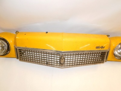 A Chevrolet Monte-Carlo yellow taxi car front bumper fascia, with two head lamps and front grille, in yellow, 175cm long. - 2