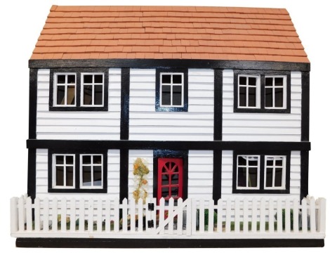 A Mock Tudor doll's house, with front opening to reveal seven rooms, together with furniture and fittings, 72cm high, 77cm wide, 27cm deep..