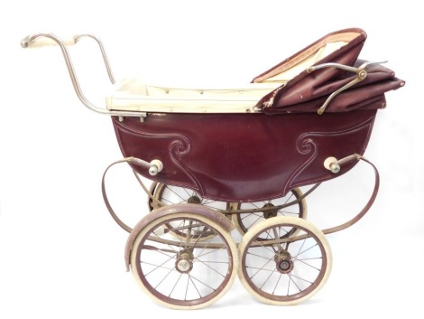 A Silver Cross coach built doll's pram, burgundy casing, cream interior, 95cm wide..