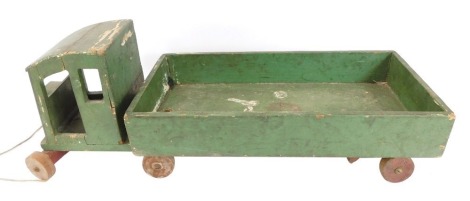 A wooden pull-a-long truck, painted green.