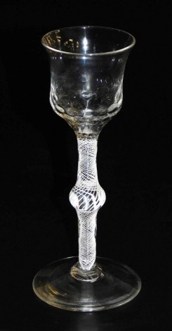 An 18thC wine glass, with dimpled thistle shaped bowl and knopped opaque lace twisted stem, on a conical foot, 15cm high.