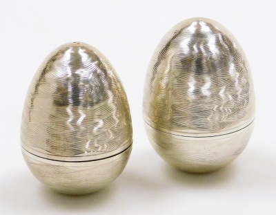 Two Elizabeth II silver eggs, decorated with engraved waved banding, the interior enclosing silver and gilt metal tulips, the other with snow drops, Peter Nicholas and Co, London 1999 and 1990, each 6cm high, 3¾oz and 2¾oz respectively. - 2