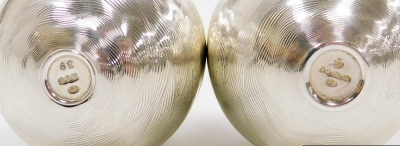 Two Elizabeth II silver eggs, decorated with engraved waved banding, the interior enclosing silver and gilt metal tulips, the other with snow drops, Peter Nicholas and Co, London 1999 and 1990, each 6cm high, 3¾oz and 2¾oz respectively. - 3