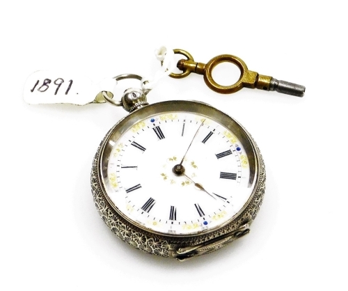 A late 19thC Swiss white metal pocket watch, open faced, key wind, decorated with leaves, flower heads, around a vacant cartouche, the white enamel dial with Roman numerals, within a gilt scroll border, the quarters marked with blue enamel dots, the case