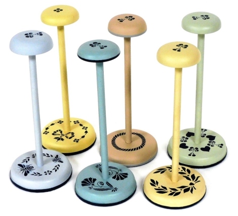 A harlequin set of six painted hat stands, each with stencilled decoration, 27cm high.