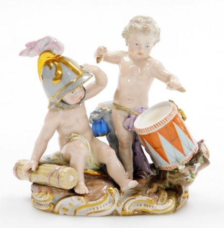 A 19thC Meissen porcelain figure group, of two putti with a drum, gilt highlighted and numbered 119-163, 14cm high. (AF)