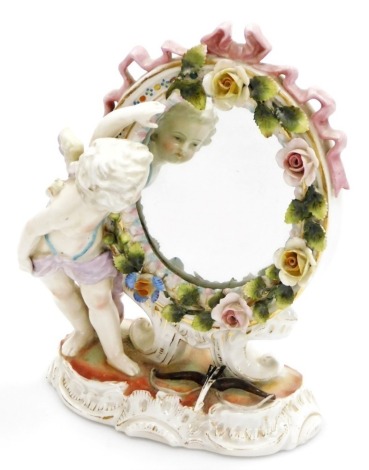 A 19thC Continental porcelain frame oval table mirror, decorated with cherubs and flowers with gilt highlights, 21cm high.