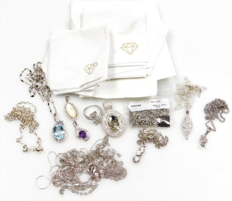 A group of silver and other necklaces and pendants, comprising a blue topaz and purple stone set loop pendant, with floral cluster, a three stone drop pendant, pear shaped pendant, various curb link chains, etc., some marked silver, together with a silver