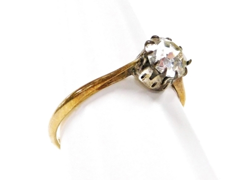 A dress ring, set with claw set imitation diamond on a rolled gold band.