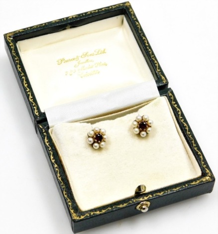 A pair of cultured pearl and garnet set floral studs, each with central garnet in claw setting surrounded by cultured pearl, in yellow metal, unmarked, 2.7g all in, boxed.