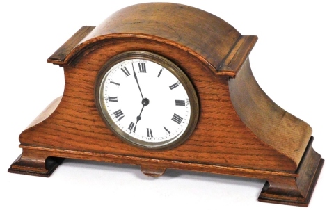 An Edwardian oak mantel clock, circular enamel dial bearing Roman numerals, Arabic numerals at quarters, Buren clockwork movement, the arched case raised on ogee bracket feet, 29.5cm wide.