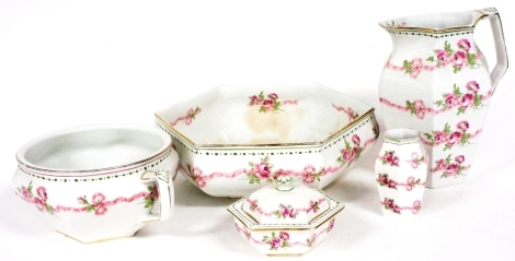 A Booths Silicon china pottery washstand set, decorated with pink ribbon and roses, comprising wash jug, bowl, chamber pot, toothbrush holder and a soap dish. (some pieces AF)