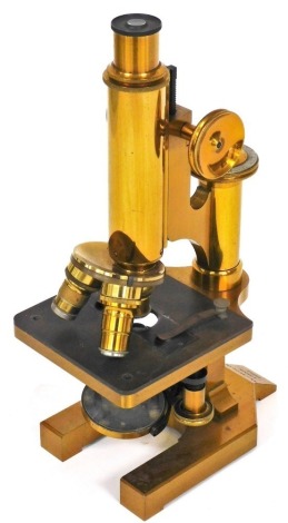 A brass compound microscope by R and J Beck Limited, London, numbered 24869, with focusing rack lenses, etc., lacking case, 29cm high.